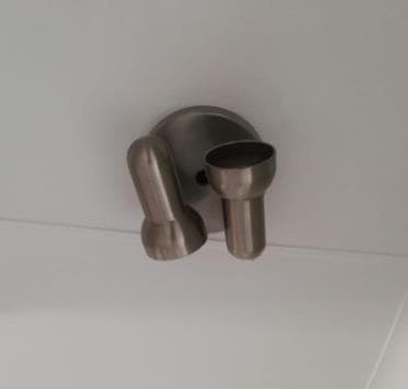 Brushed-metal two-head ceiling spotlight installed on a white ceiling