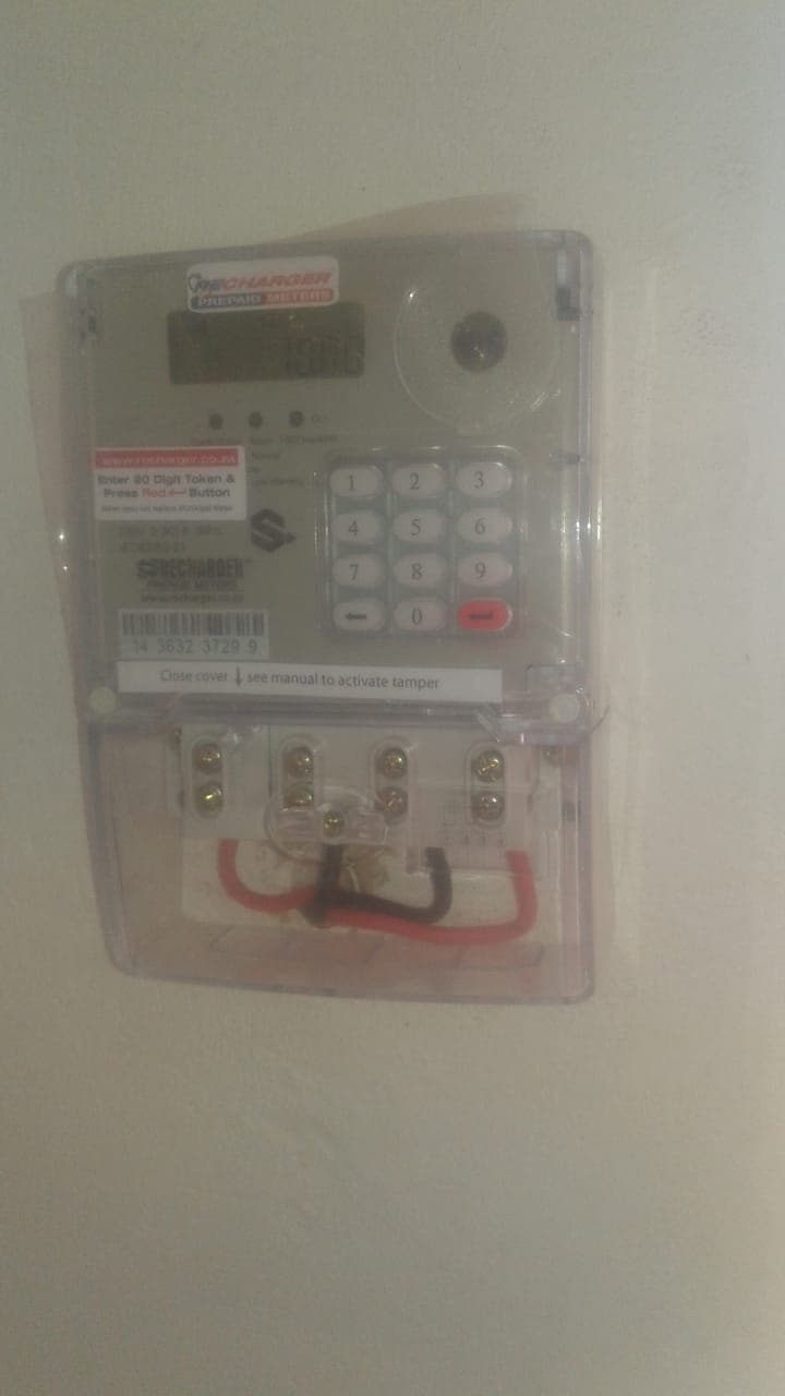 Recharger prepaid electricity meter installed on a wall with keypad and terminal wiring visible