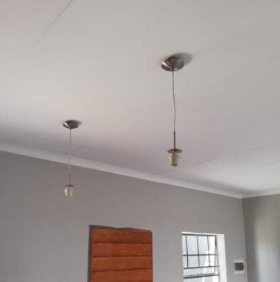 Two pendant light fittings newly installed on a white residential ceiling